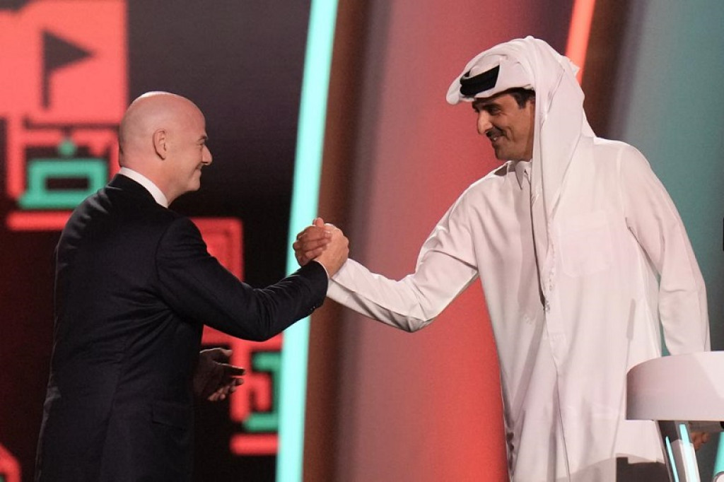FIFA President Gianni Infantino, left, and Emir of Qatar Sheikh Tamim bin Hamad Al Thani shake hands before the 2022 soccer World Cup draw at the Doha Exhibition and Convention Center in Doha, Qatar, Friday, April 1, 2022. (AP Photo)
